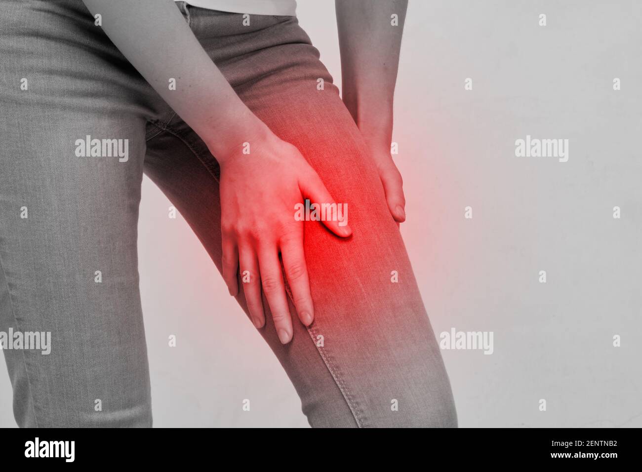 La donna della persona sente il dolore nella parte della coscia della gamba. Foto Stock