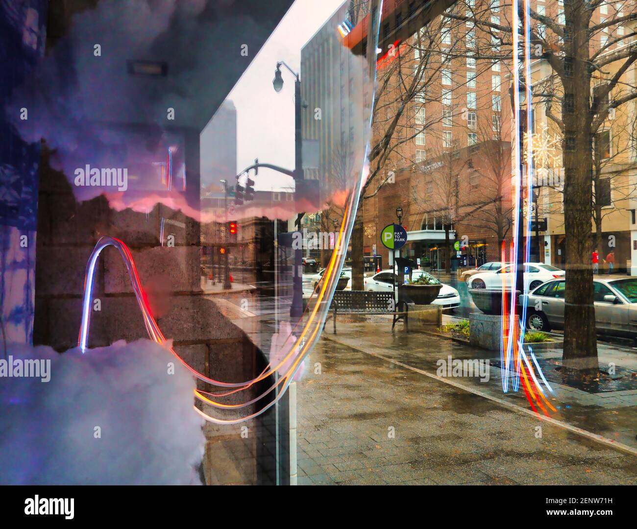 Una vista dei riflessi delle finestre al neon e di una scena stradale Foto Stock