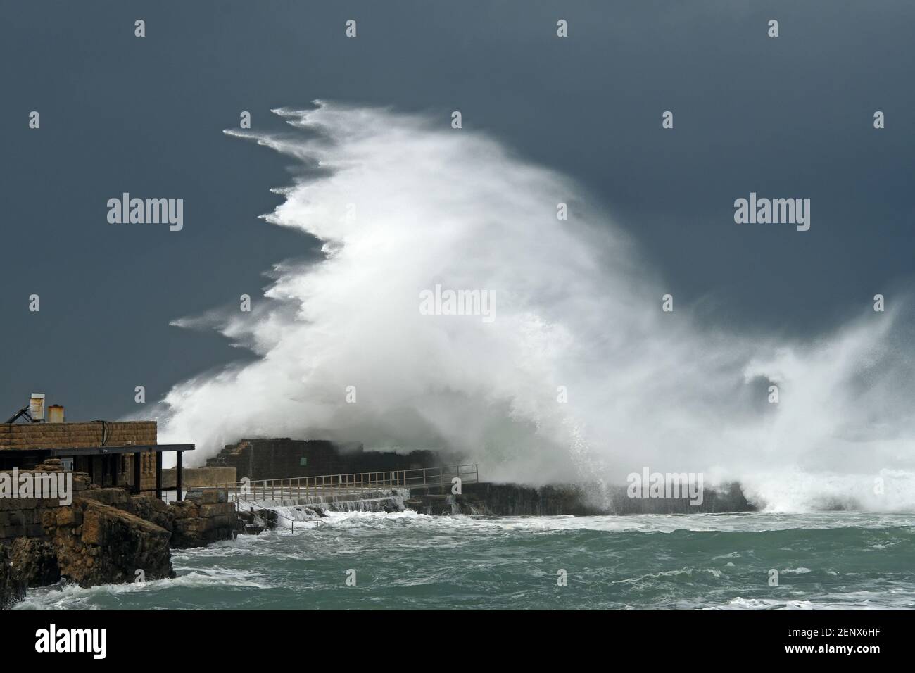 Rottura dell'onda sul muro di pietra in un giorno d'inverno tempestoso Foto Stock