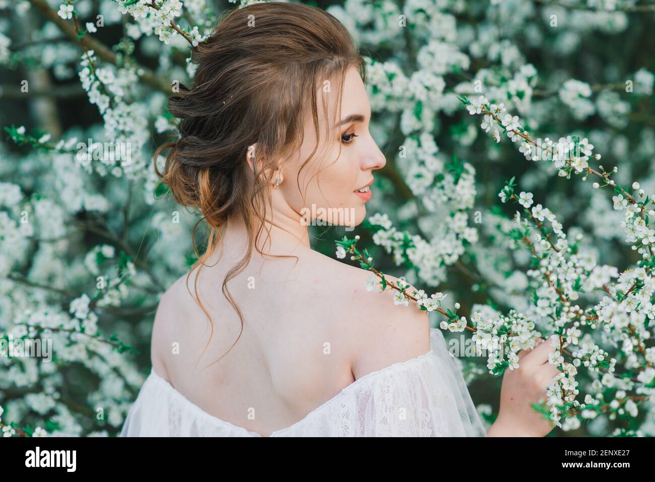 Giovane bella donna in giardino fiorito. Sposa in abito da sposa Foto stock  - Alamy