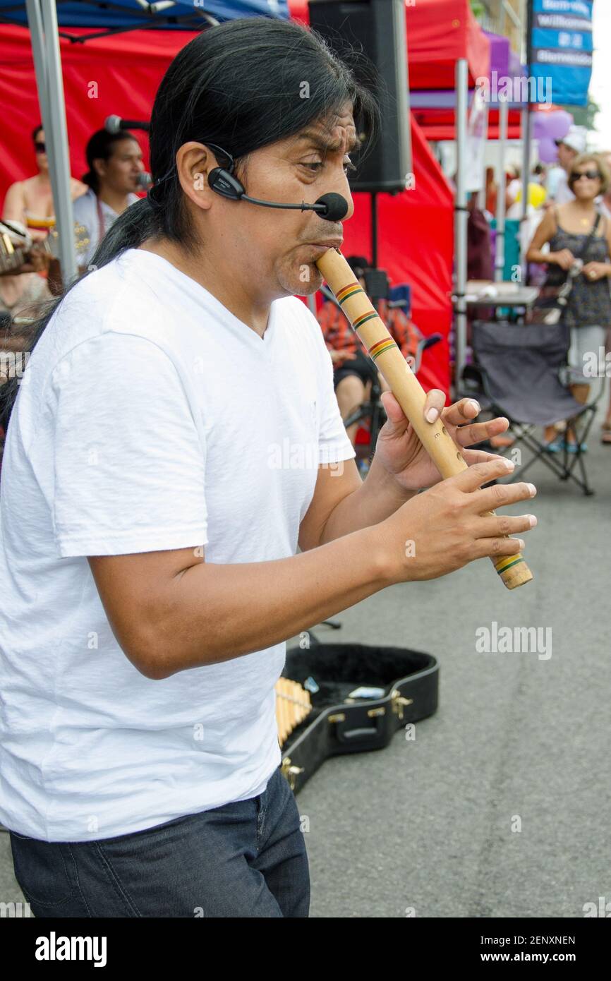 Salsa sulle scene del Festival di San Clair: Un musicista di strada suona un flauto di legno. Il flutista proviene dalle prime nazioni, con una lunga coda di pontile e un'ora Foto Stock