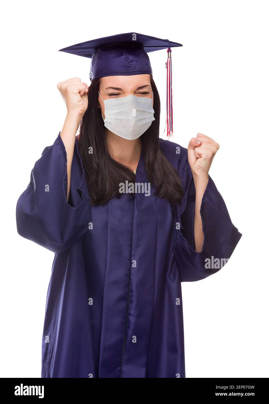 Graduazione femminile indossando maschera medica e cappuccio e abito cheering isolato su uno sfondo bianco. Foto Stock