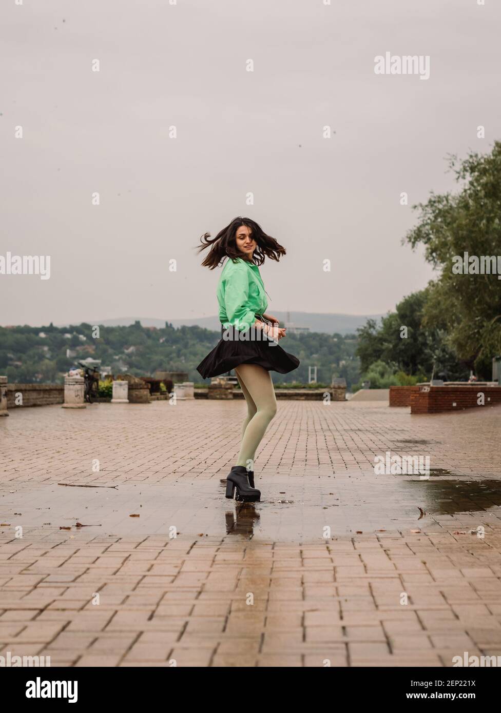 una giovane donna che balla sotto la pioggia Foto stock - Alamy