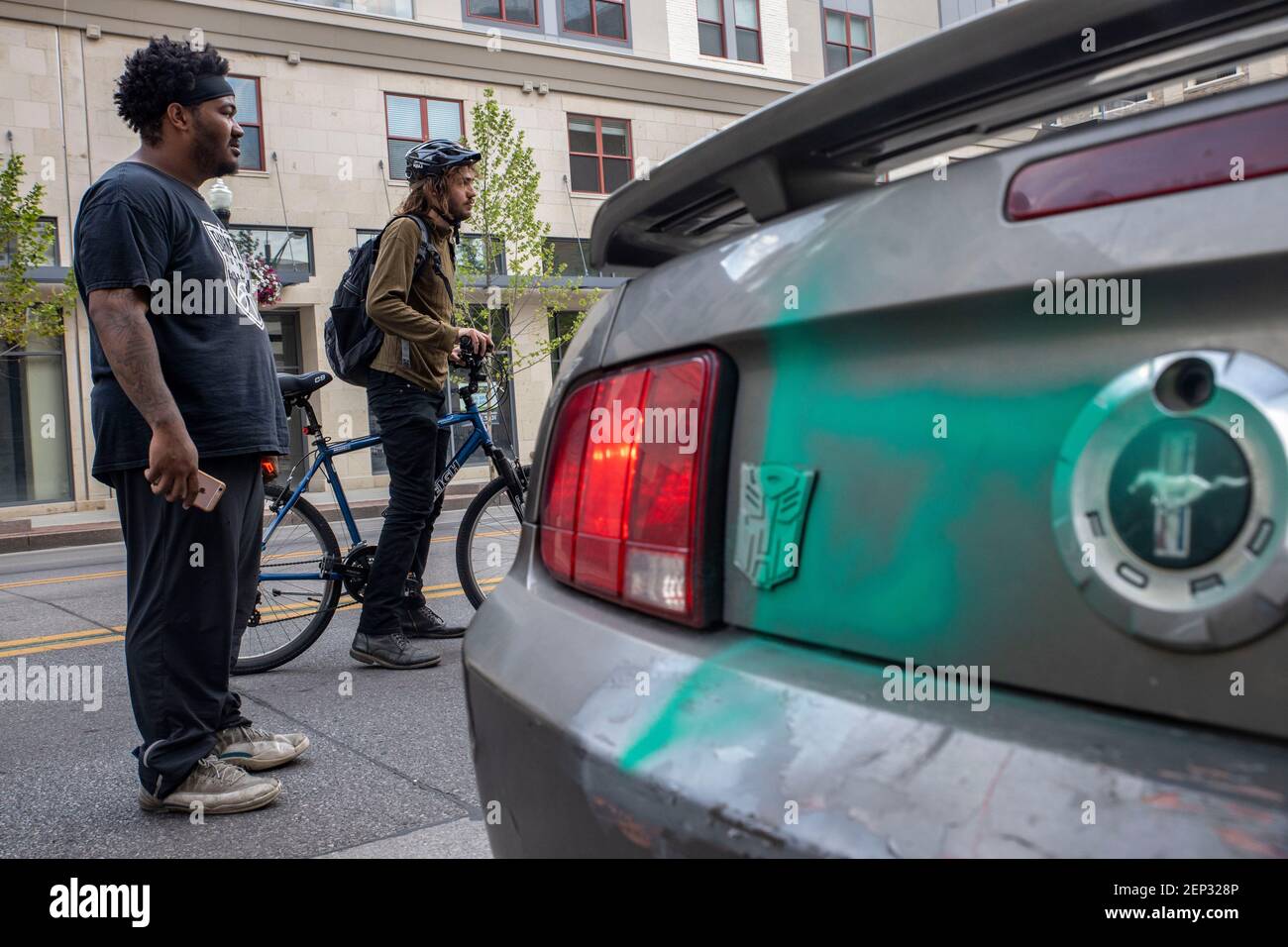 Demetrius Ervin (22) partecipante attivo e organizzatore di molte delle proteste durante la settimana si trova accanto al suo mustang che è stato verniciato a spruzzo durante le precedenti proteste di George Floyd.i manifestanti si sono riuniti di fronte allo state House Ohio e hanno marciato a nord su High St. In una dimostrazione contro la brutalità della polizia, Razzismo e l'uccisione di George Floyd da parte dell'ufficiale della polizia di Minneapolis Derek Chauvin il 25 maggio 2020. Foto Stock