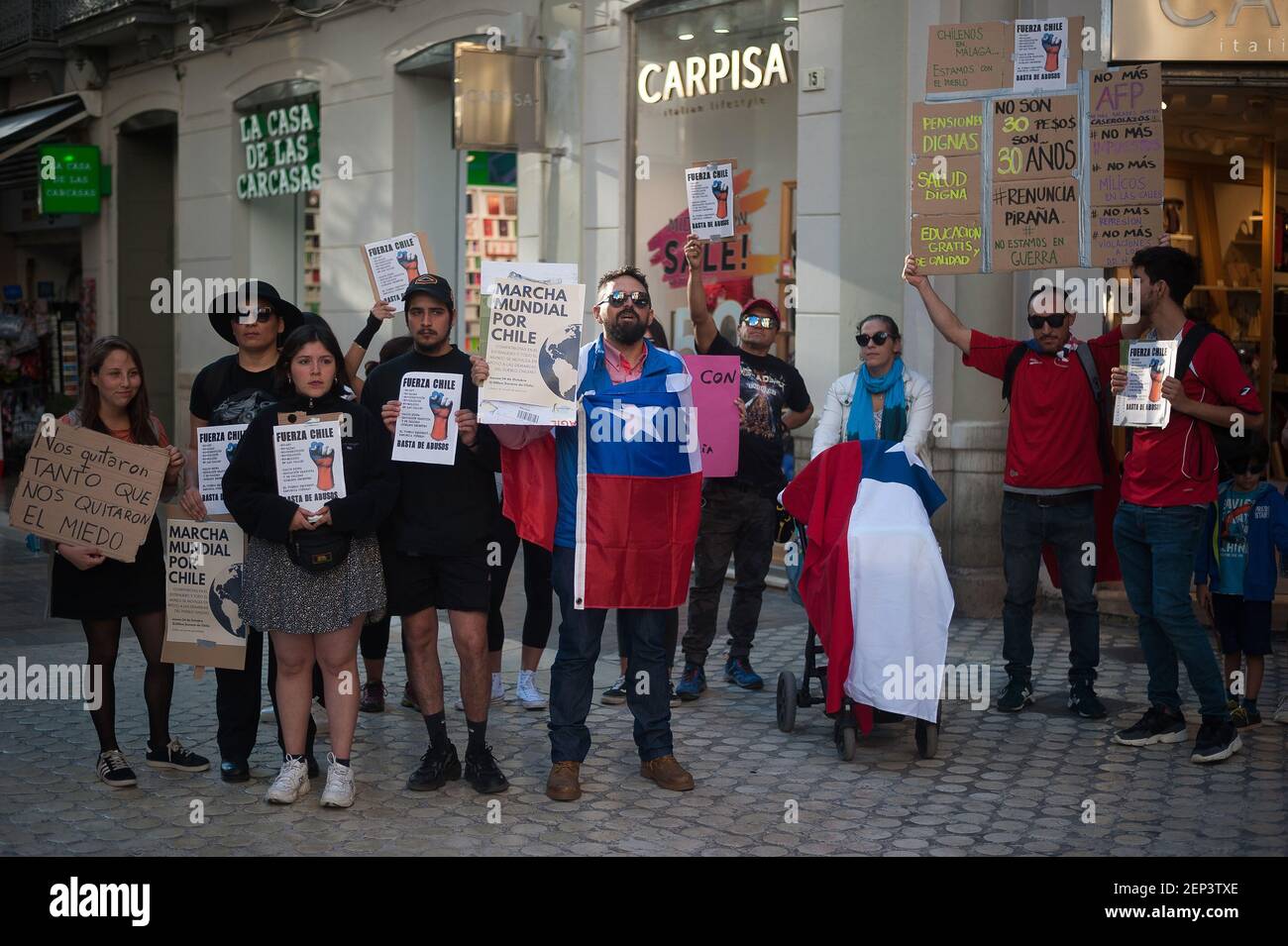 Manifestanti che tengono i cartelli durante la dimostrazione. I cileni  protestano contro il consolato cileno per sostenere i loro compatrioti e  contro le misure economiche. Almeno 18 persone sono morte durante gli