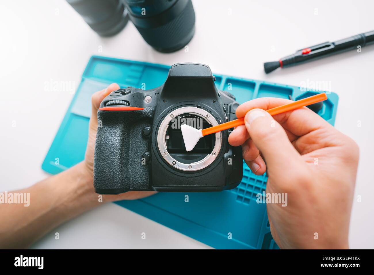 Primo piano della pulizia manuale della matrice di una fotocamera con un detergente per sensori della fotocamera o un bastoncino di pulizia. Cura delle attrezzature fotografiche Foto Stock