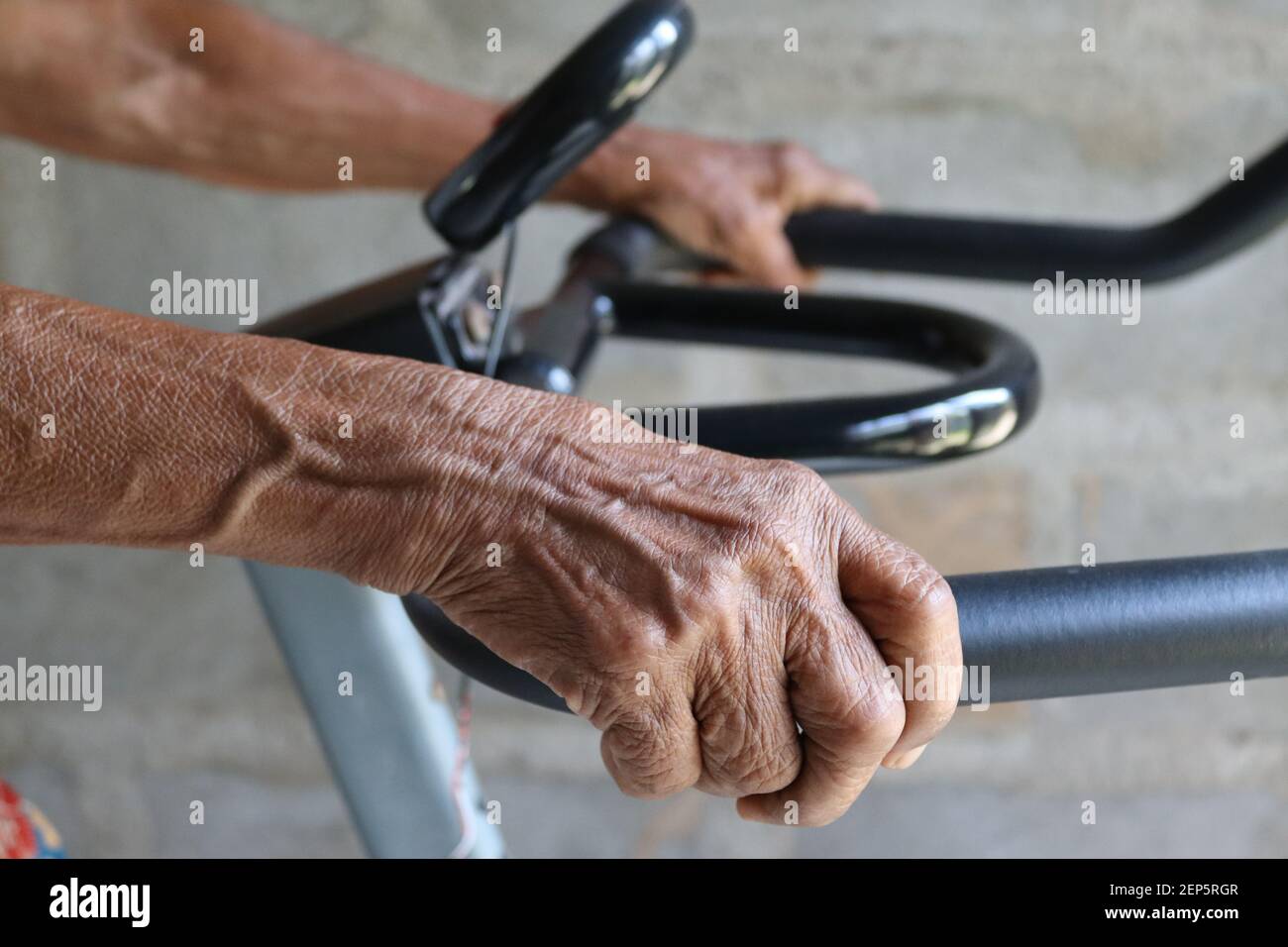 "i nostri allenatori utilizzano la tecnologia attuale", mamma di 80 anni che usa una moderna bicicletta da ginnastica per il suo allenamento quotidiano. Foto Stock