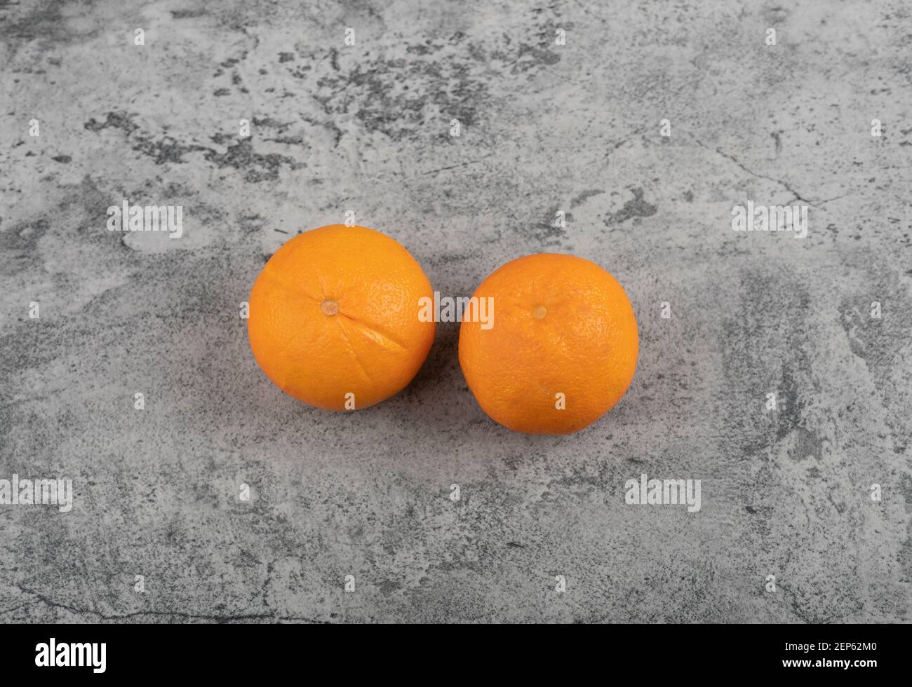 Due frutti di arancia freschi isolati su tavola di pietra Foto Stock