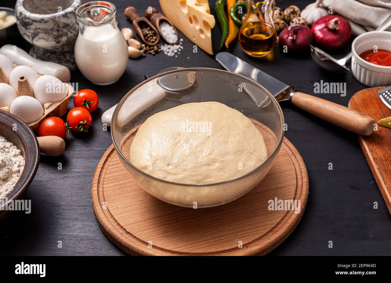 Pizza classica margherita con formaggio a forma di cuore. Preparazione di una cena di gala a fasi per due a casa in onore del giorno di San Valentino. Foto Stock