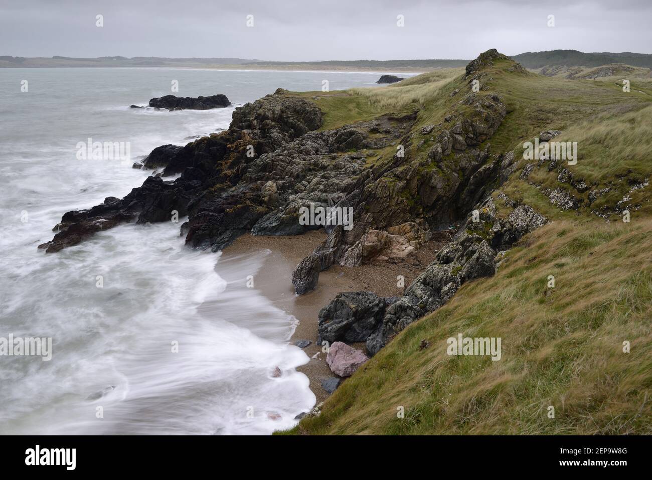 La marea entrante che lava una spiaggia sull'isola di Llanddwyn, Anglesey, Galles. Foto Stock