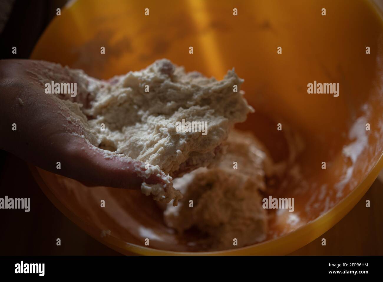 Donna che mescola farina e acqua per preparare un impasto Foto Stock