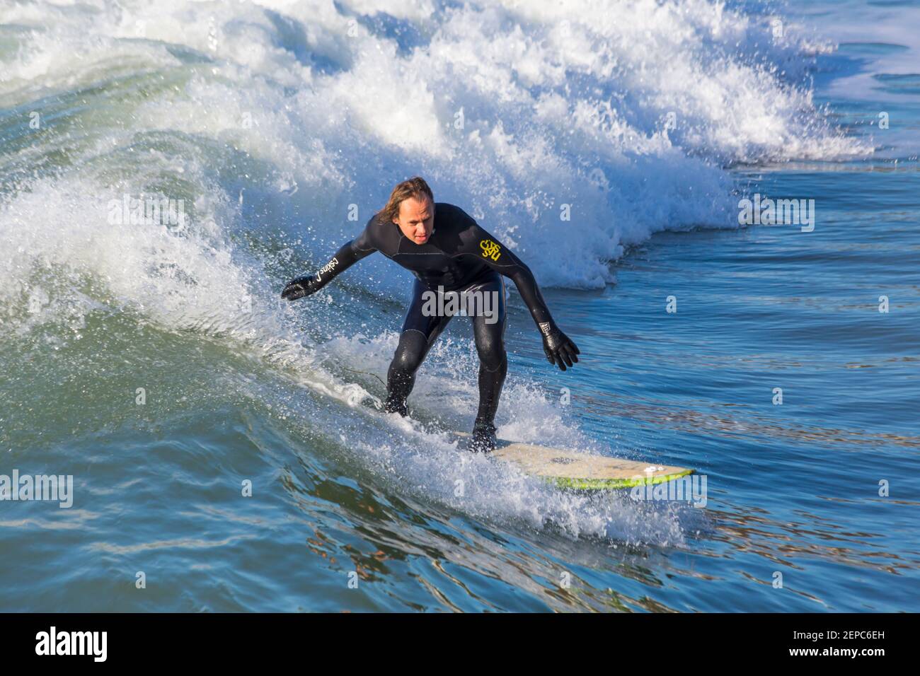 Bournemouth, Dorset UK. 27 febbraio 2021. Tempo nel Regno Unito: Bella giornata calda e soleggiata con cielo blu e sole ininterrotto alle spiagge di Bournemouth mentre le persone si dirigono verso il mare per il loro esercizio quotidiano durante Lockdown 3. I surfisti possono praticare il surf sotto il sole. Credit: Carolyn Jenkins/Alamy Live News Foto Stock