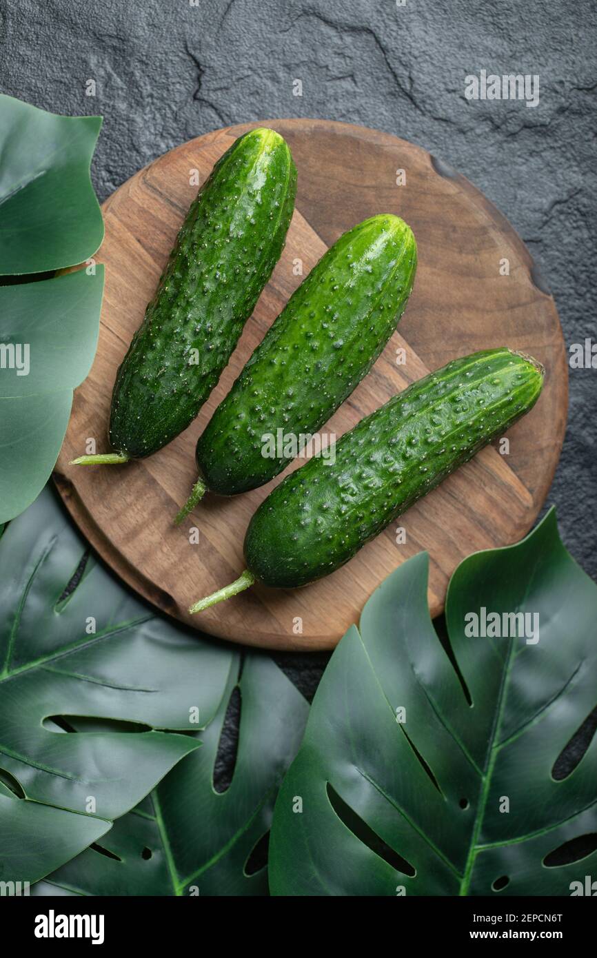 Tre cetrioli freschi su tavola di legno. Foto verticale Foto Stock