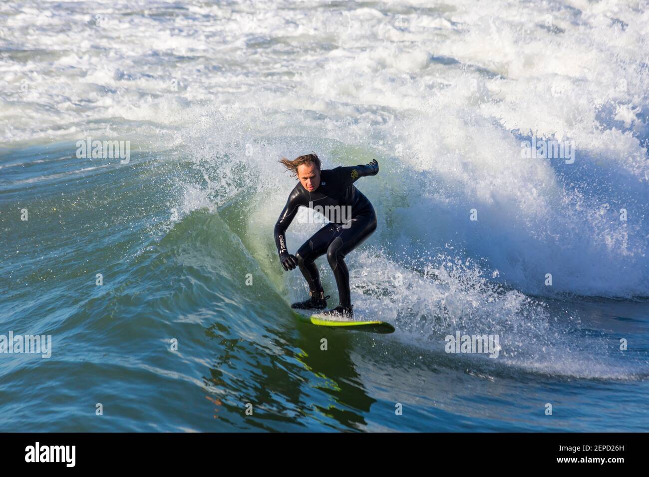 Bournemouth, Dorset UK. 27 febbraio 2021. Tempo nel Regno Unito: Bella giornata calda e soleggiata con cielo blu e sole ininterrotto alle spiagge di Bournemouth mentre le persone si dirigono verso il mare per il loro esercizio quotidiano durante Lockdown 3. I surfisti possono praticare il surf sotto il sole. Credit: Carolyn Jenkins/Alamy Live News Foto Stock