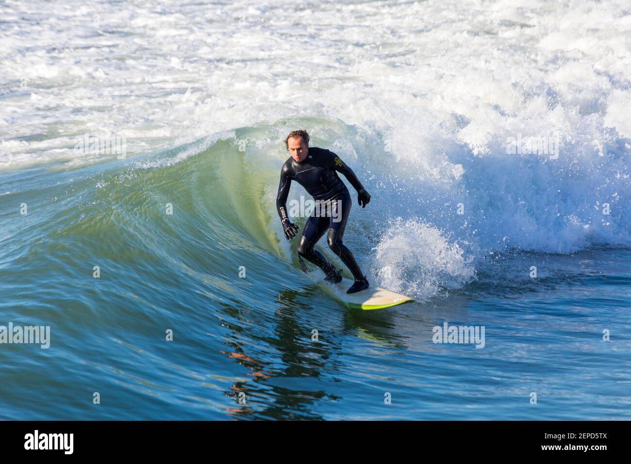 Bournemouth, Dorset UK. 27 febbraio 2021. Tempo nel Regno Unito: Bella giornata calda e soleggiata con cielo blu e sole ininterrotto alle spiagge di Bournemouth mentre le persone si dirigono verso il mare per il loro esercizio quotidiano durante Lockdown 3. I surfisti possono praticare il surf sotto il sole. Credit: Carolyn Jenkins/Alamy Live News Foto Stock
