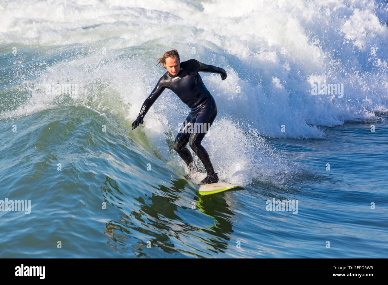 Bournemouth, Dorset UK. 27 febbraio 2021. Tempo nel Regno Unito: Bella giornata calda e soleggiata con cielo blu e sole ininterrotto alle spiagge di Bournemouth mentre le persone si dirigono verso il mare per il loro esercizio quotidiano durante Lockdown 3. I surfisti possono praticare il surf sotto il sole. Credit: Carolyn Jenkins/Alamy Live News Foto Stock
