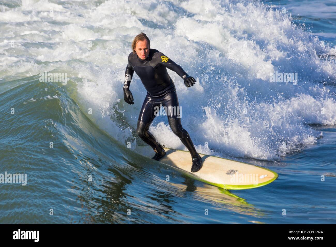 Bournemouth, Dorset UK. 27 febbraio 2021. Tempo nel Regno Unito: Bella giornata calda e soleggiata con cielo blu e sole ininterrotto alle spiagge di Bournemouth mentre le persone si dirigono verso il mare per il loro esercizio quotidiano durante Lockdown 3. I surfisti possono praticare il surf sotto il sole. Credit: Carolyn Jenkins/Alamy Live News Foto Stock