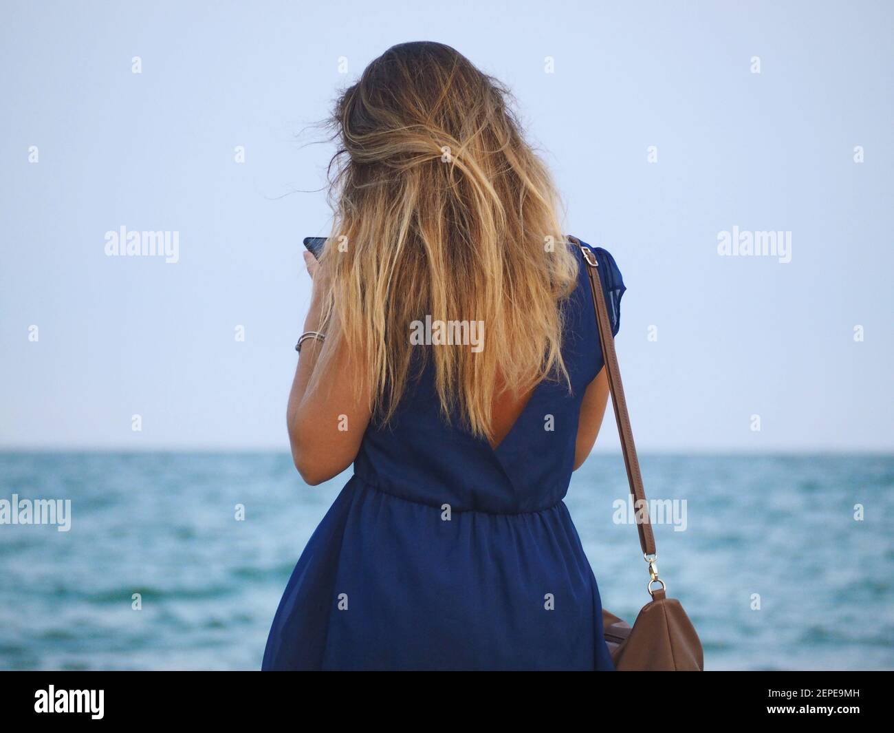 Donna con lunghi capelli biondi e una pratica al spiaggia Foto Stock