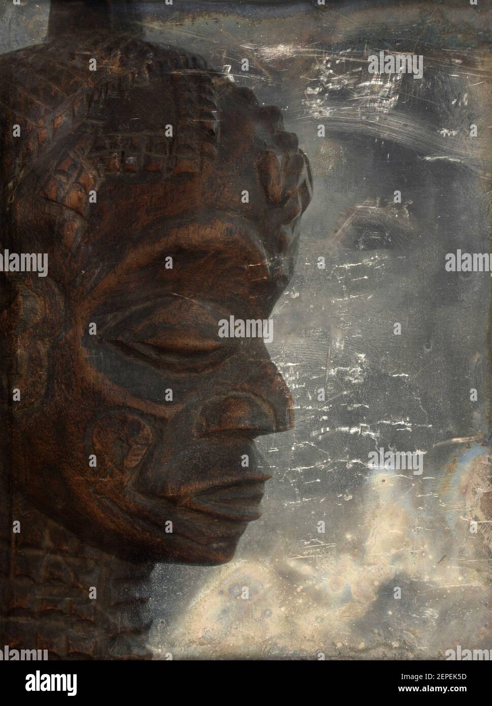 Testa di scultura africana in legno su sfondo grunge. Foto Stock