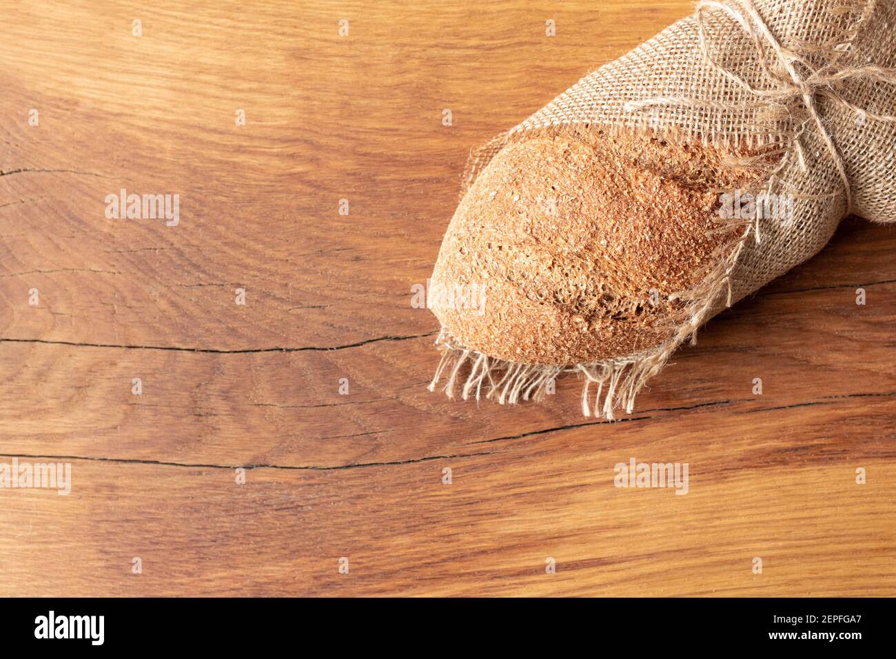 Pane fatto in casa appena sfornato con crusca su fondo di legno e burlap e con un salice sprig. Foodphoto. Foto di alta qualità Foto Stock