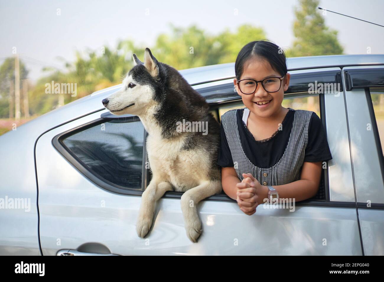 Ritratto di una ragazza e Husky siberiano in macchina finestra Foto Stock