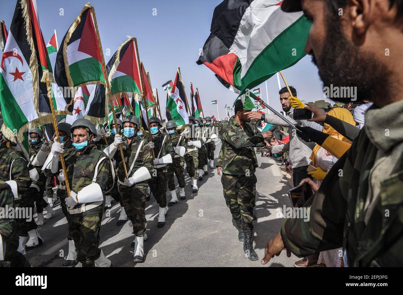 27 febbraio 2021, Algeria, Tindouf: La gente guarda la sfilata delle truppe saharawi durante le celebrazioni del 45° anniversario della dichiarazione della Repubblica Araba Democratica del Sahrawi (SADR), vicino alla città algerina sudoccidentale di Tindouf, considerata capitale saharawi in esilio. Il SADR fu proclamato dal fronte di liberazione del Polisario il 27 febbraio 1976 nella regione del Sahara occidentale dopo l'evacuazione delle forze colonizzanti spagnole. Il governo SADR controlla quasi il 20·25% del territorio che rivendica, mentre il Marocco controlla e amministra il resto del territorio contestato, e lo chiama Foto Stock