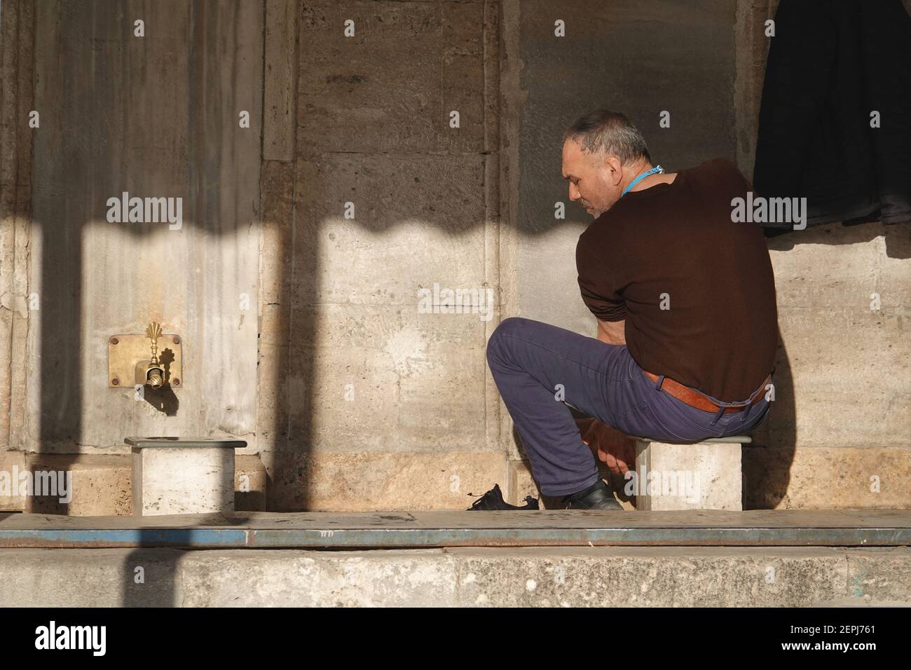 Uomo che esegue abluzioni a Eminonu Yeni Cami, Istanbul Foto Stock