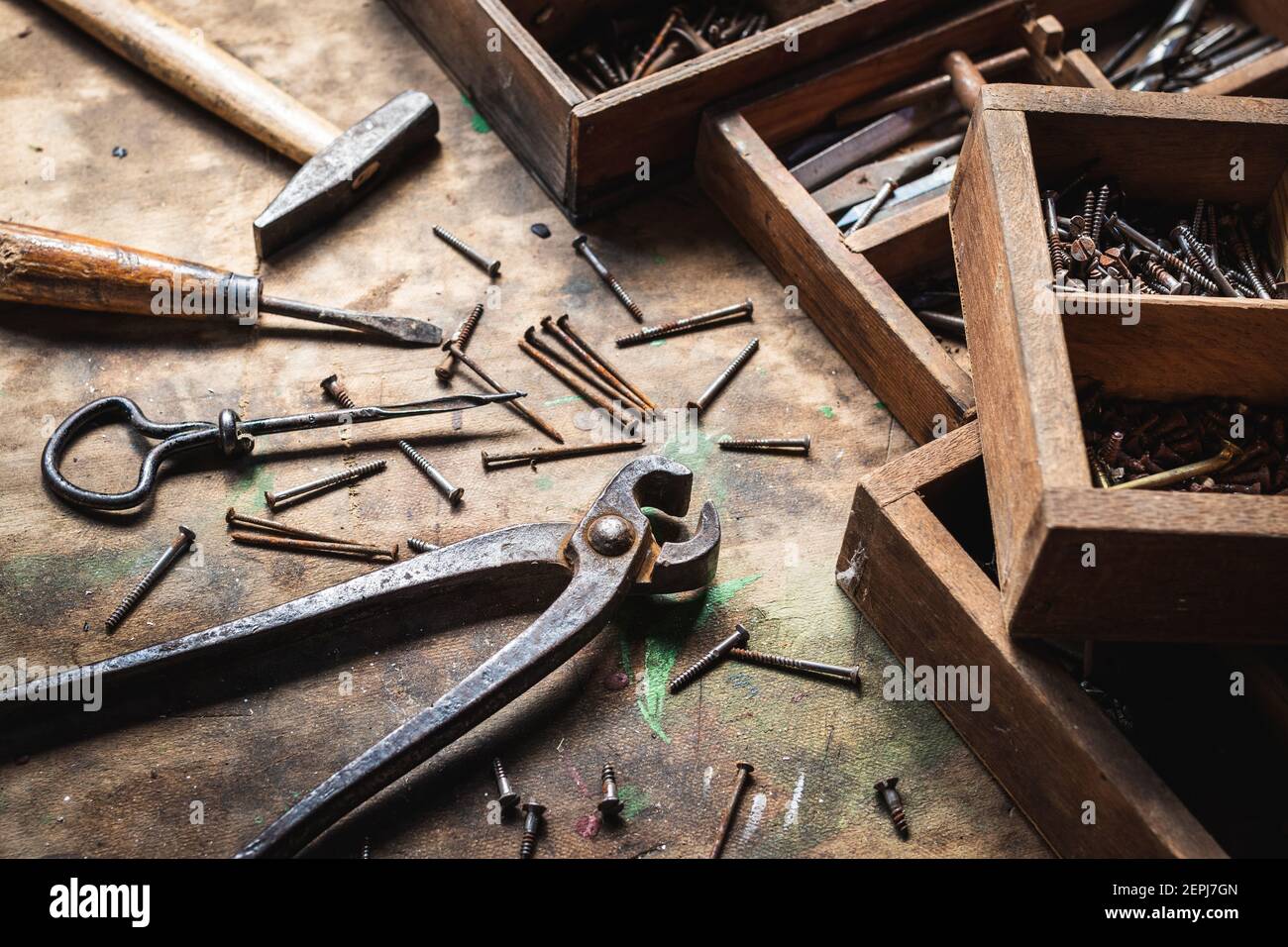 Attrezzatura vintage e cassetta attrezzi su tavolo in legno. Pinze, martello, cacciavite, bullone, vite e altri attrezzi manuali in officina Foto Stock