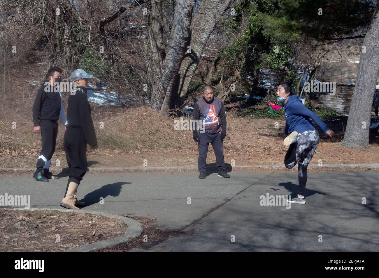 4 i newyorkesi cinesi americani giocano a Jianzi, un gioco in cui l'oggetto è quello di mantenere il peso pesante shuttlecock in aria. A Flushing, Queens, New York. Foto Stock