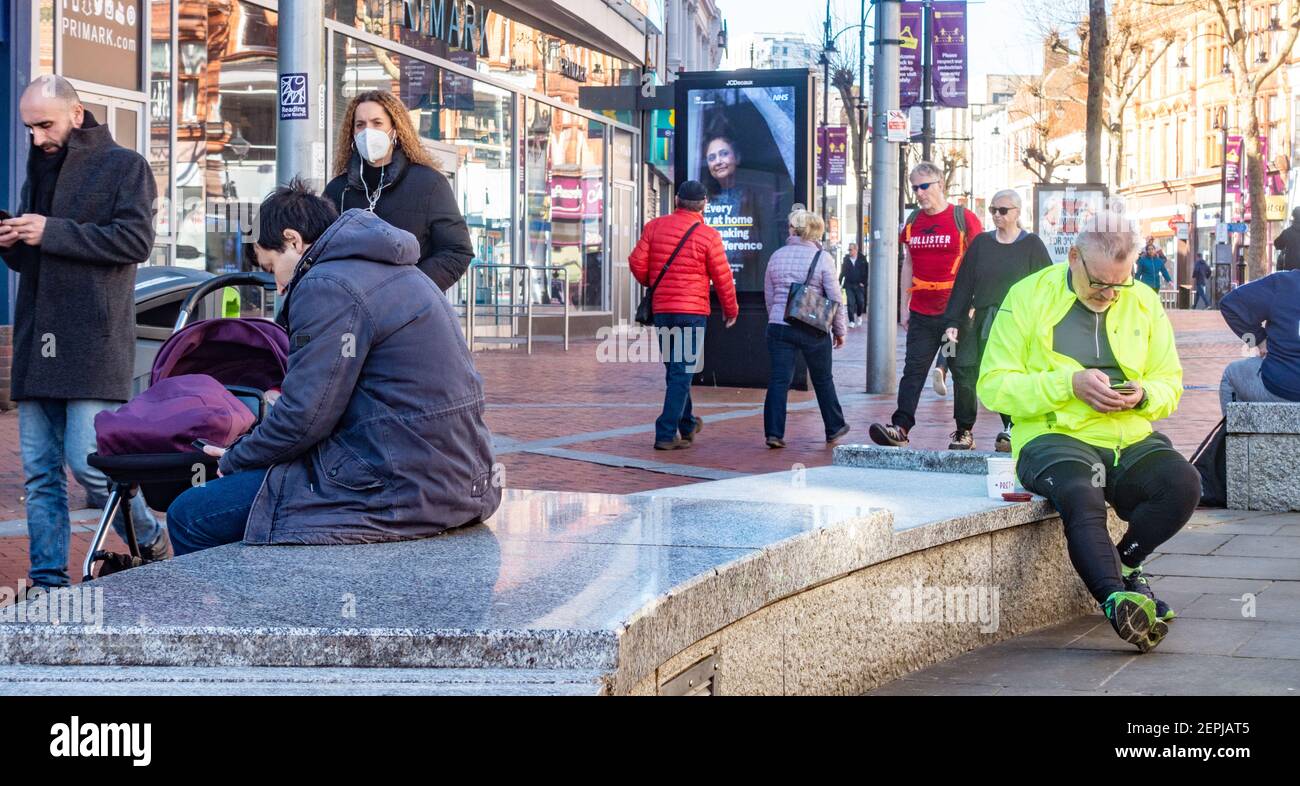 Gli uomini si siedono su banchi di marmo curvi in Broad Street, Reading, UK Foto Stock