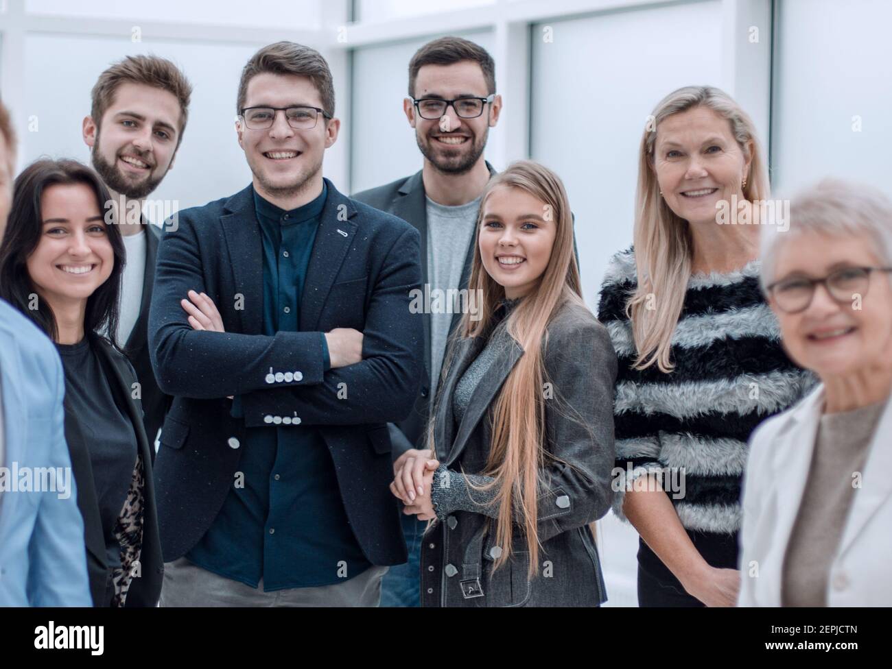 Team aziendale sorridente e sicuro che si sta insieme Foto Stock