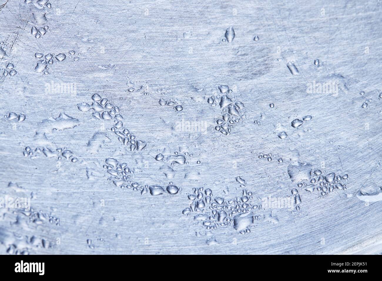 gocce di liquido sulla superficie metallica color argento. sfondo. messa a fuoco morbida Foto Stock