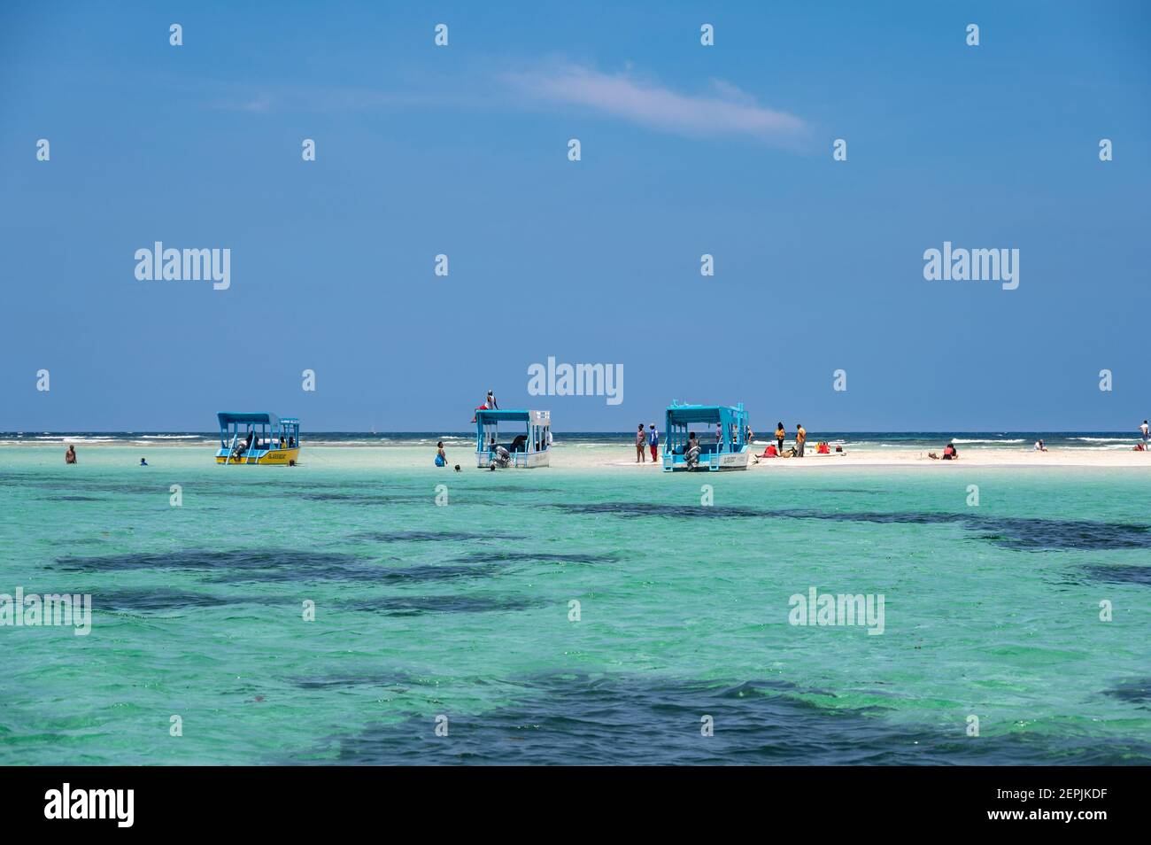 Diverse barche con fondo di vetro ormeggiate da una bassa marea di sabbia con persone sulla sabbia, Diani, Kenya Foto Stock