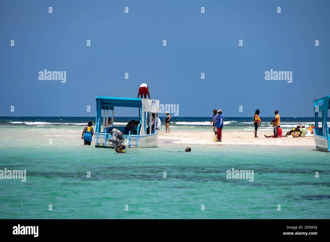 Diverse barche con fondo di vetro ormeggiate da una bassa marea di sabbia con persone sulla sabbia, Diani, Kenya Foto Stock
