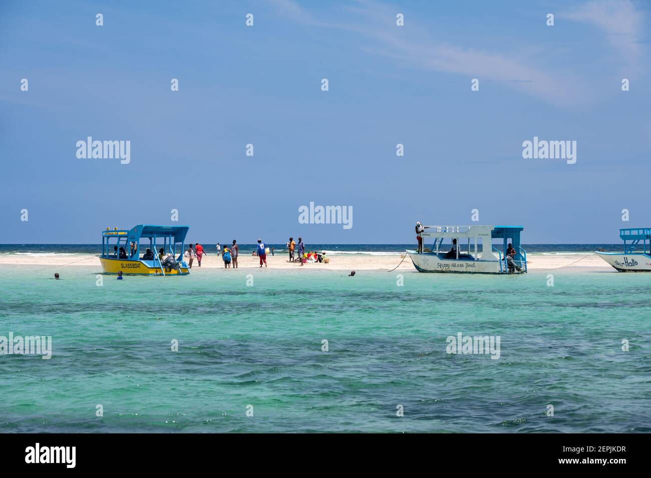 Diverse barche con fondo di vetro ormeggiate da una bassa marea di sabbia con persone sulla sabbia, Diani, Kenya Foto Stock