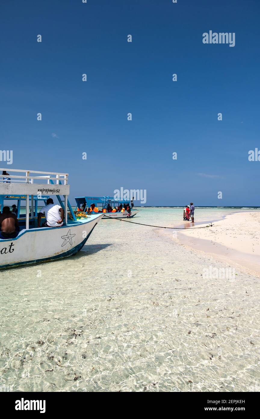 Una barca con fondo di vetro ormeggiata da una bassa riva di sabbia con persone sulla sabbia, Diani, Kenya Foto Stock