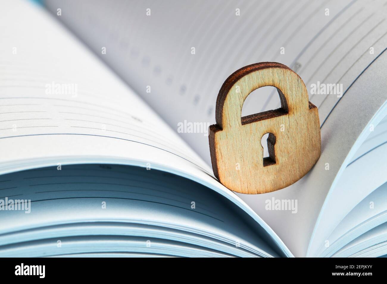 concetto di privacy aziendale. lucchetto in legno su un blocco note aperto. spazio di copia Foto Stock