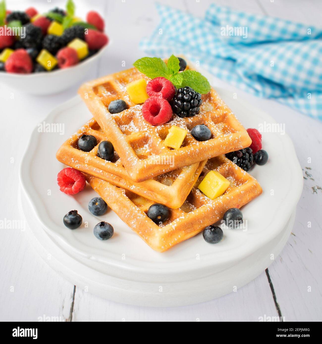 Waffle con zucchero in polvere e frutta fresca. Foto Stock