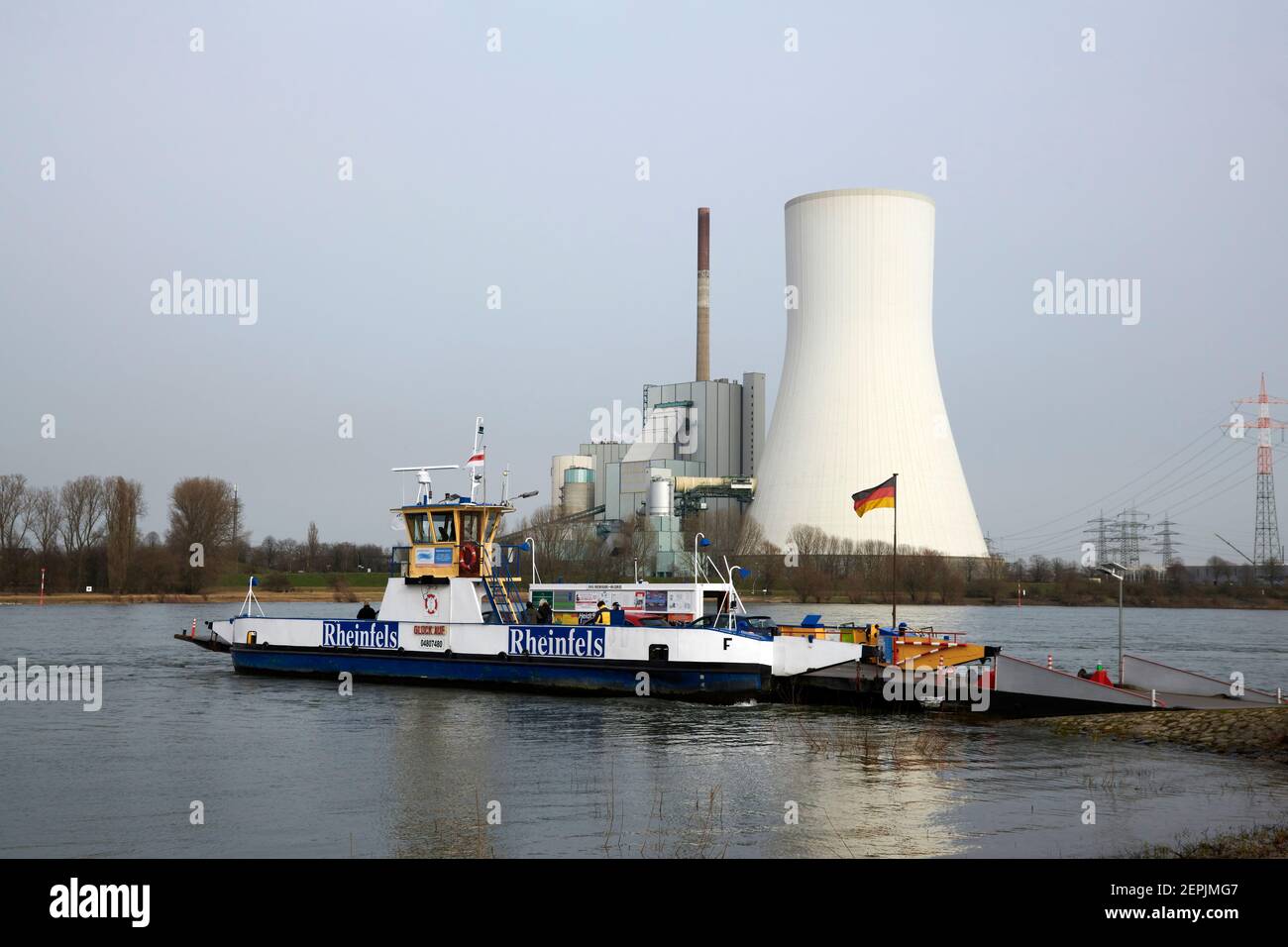 Die Rheinfaehre nach Orsoy legt in Richtung Dueisburg Walsum ab. Der Blick Kommt aus Richtung Orsoy. Im Hintergrund ist das Kraftwerk Walsum mit dem m Foto Stock