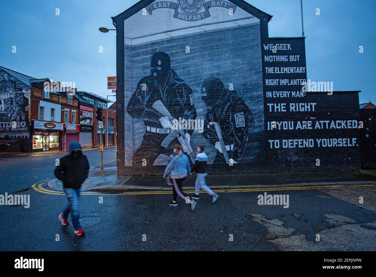BELFAST, IRLANDA DEL NORD - Febbraio 23: Pedoni che passavano davanti a un murale paramilitare lealista sulla strada di Newtownards il 23 febbraio 2021. Foto Stock