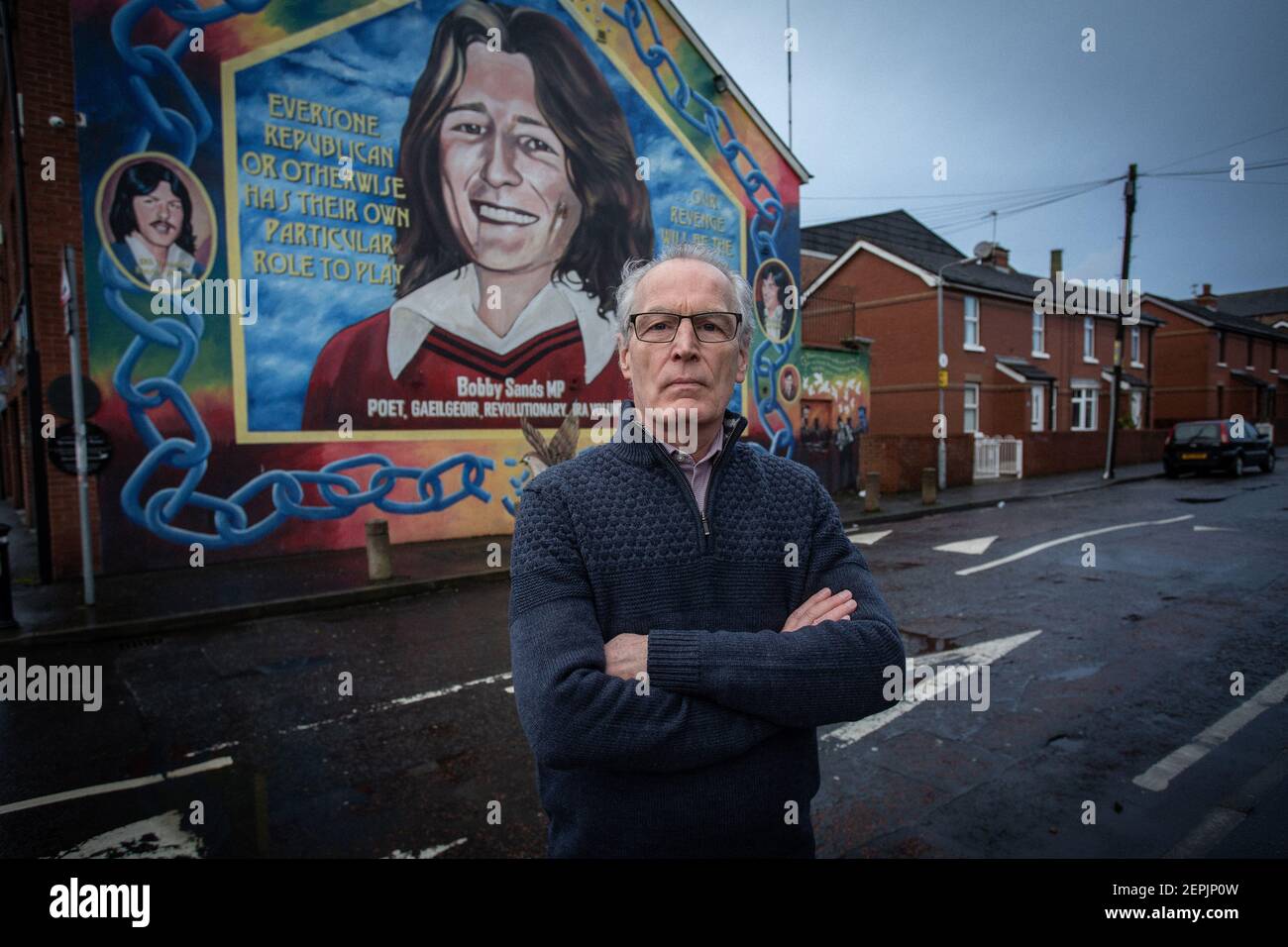 BELFAST, IRLANDA DEL NORD - Febbraio, 23 Gerry Kelly di fronte al murale di Bobby Sands presso la sede centrale del Sinn Fein riceve una chiamata per l'allerta contro la bomba Foto Stock