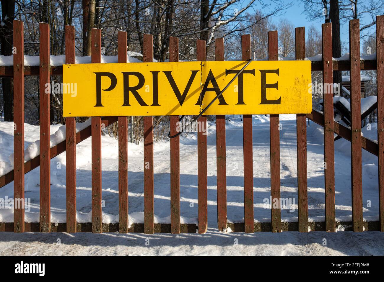 Cartello privato giallo sul cancello di legno in inverno Foto Stock