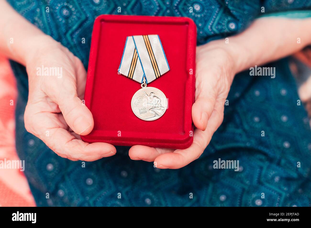 SAN PIETROBURGO, RUSSIA - 8 MARZO 2020 Medaglia vittoria 1945- 2020 seconda guerra mondiale in donne anziane mani da vicino Foto Stock