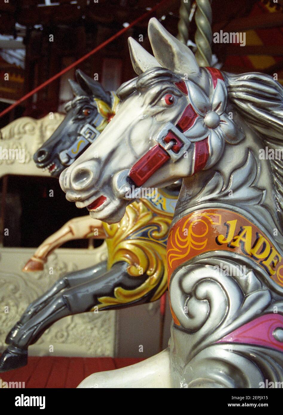 Cavalli tradizionali in legno su una giostra in un divertimento inglese parcheggio Foto Stock