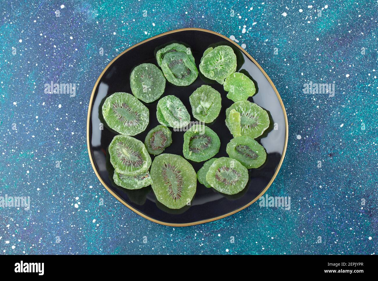 Vista dall'alto di fette di kiwi asciutte sulla piastra nera. Chiudere la foto Foto Stock