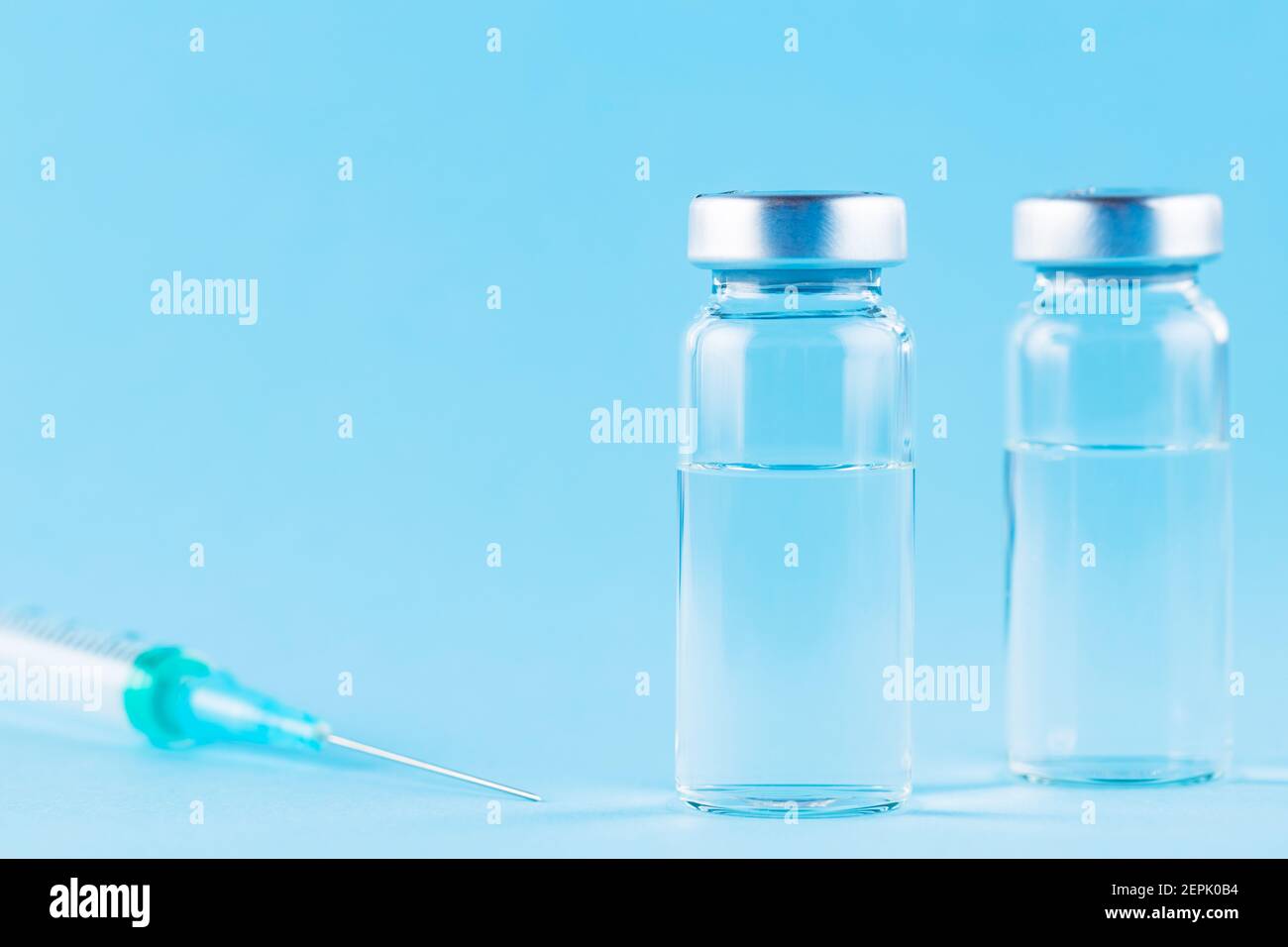 Iniezione di vaccino e siringa. Vaccini e siringhe su sfondo blu per la prevenzione e l'immunizzazione. Vaccino e concetto medico sanitario. Copia Foto Stock