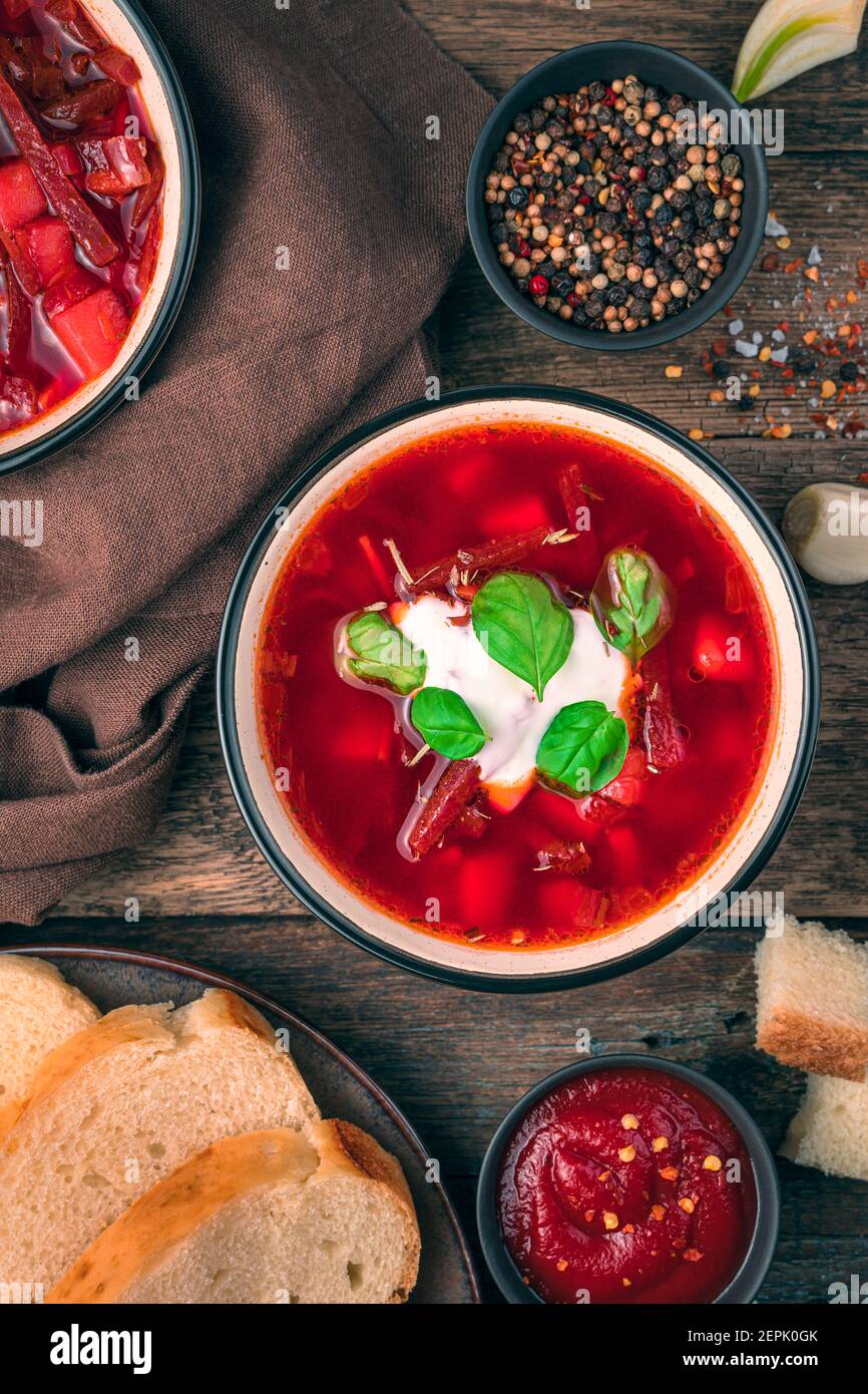 Una porzione di zuppa di verdure con pomodoro e barbabietola, panna acida e basilico. Borscht fresco e delizioso. Foto Stock