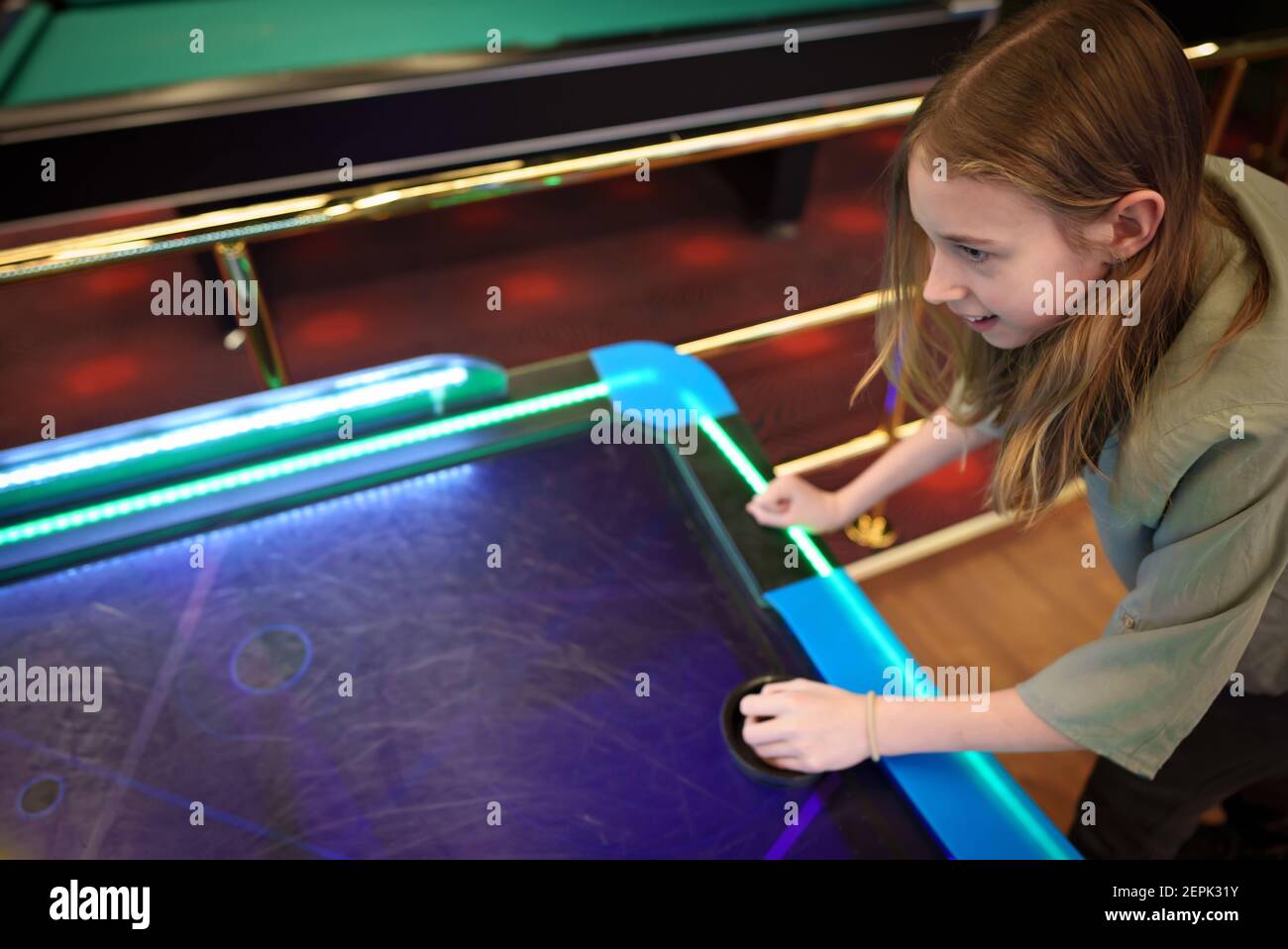 Tween Girl gioca a hockey nel centro di intrattenimento. Foto Stock