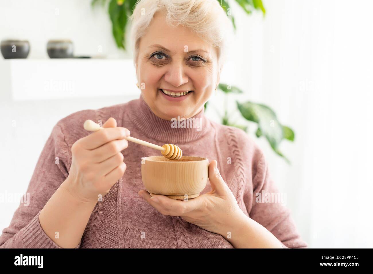 donna anziana miele a casa, stile di vita concetto Foto Stock