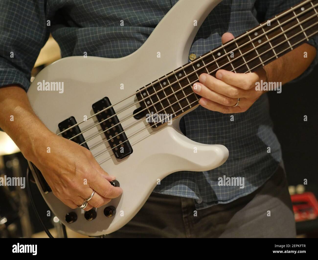 Chitarrista suonante chitarra basso, musicista Pucking Strings of Musical Instrument, bassista Band Member Creating Music, jamming Session Foto Stock